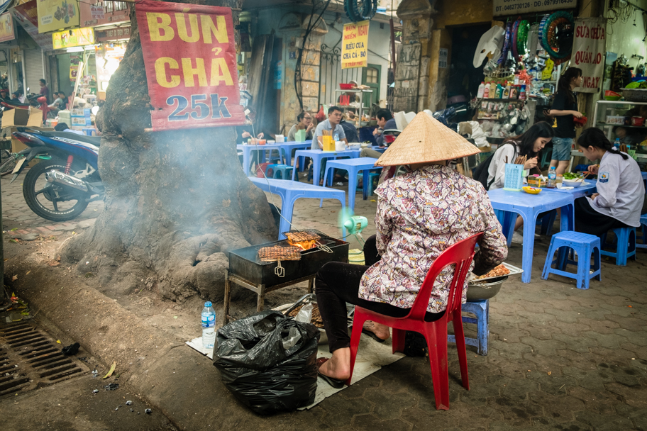 A Vietnamese woman makes street food in Hanoi, Vietnam. Photo by Barbara Cameron Pix, Food & Travel Photographer